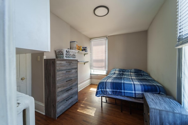 bedroom with lofted ceiling, wood finished floors, and baseboards