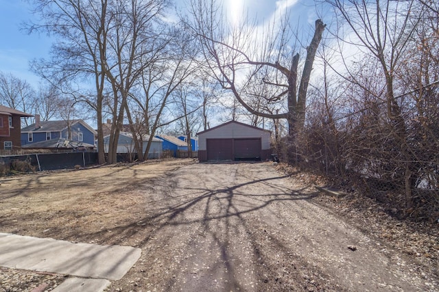 view of yard featuring a garage, an outdoor structure, and fence