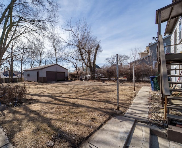 view of yard with stairs, an outbuilding, fence, and a garage