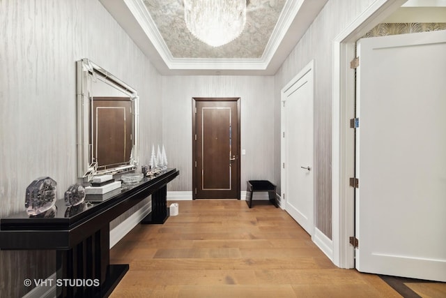 corridor featuring wood finished floors, baseboards, and ornamental molding