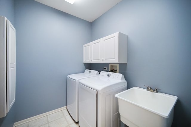 washroom with light tile patterned floors, separate washer and dryer, a sink, baseboards, and cabinet space