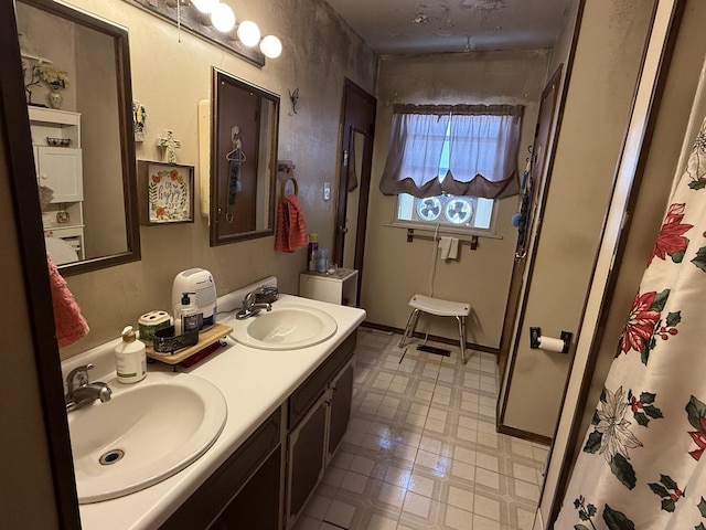 full bathroom with double vanity, a sink, and tile patterned floors