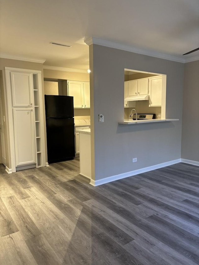 kitchen featuring ornamental molding, freestanding refrigerator, and white cabinets