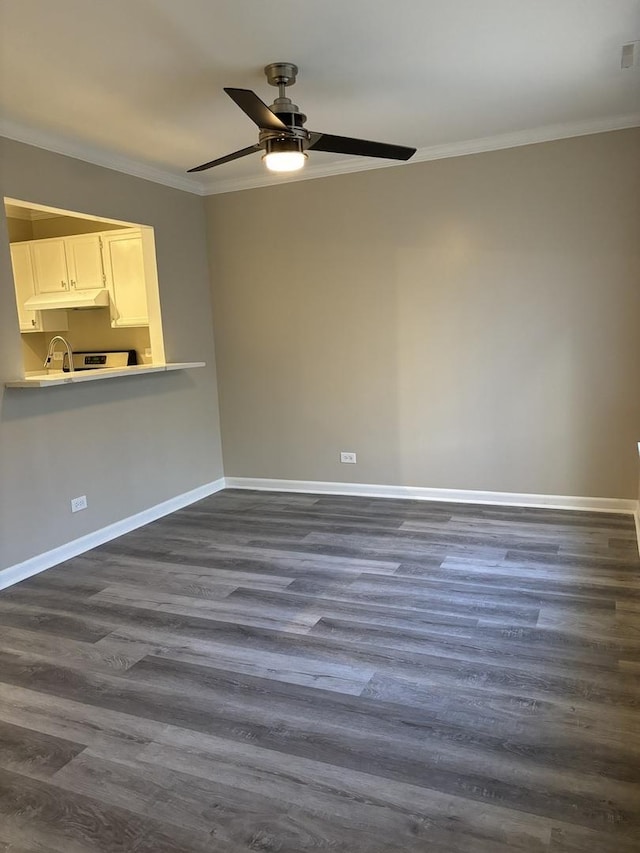 empty room featuring ceiling fan, baseboards, dark wood finished floors, and crown molding