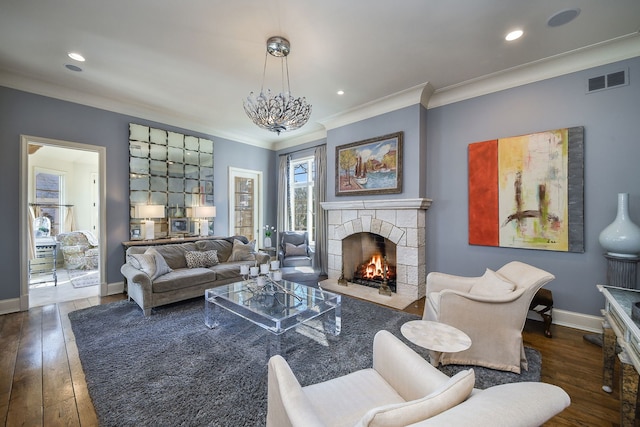 living area with a fireplace, baseboards, wood-type flooring, and ornamental molding