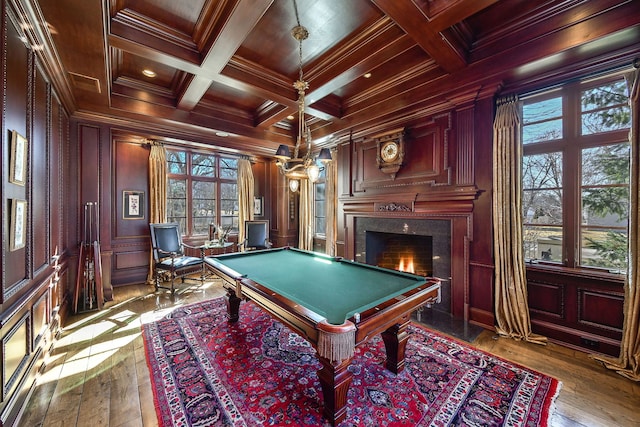 game room featuring beamed ceiling, coffered ceiling, a fireplace, and ornamental molding