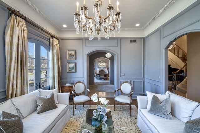 living area with visible vents, french doors, arched walkways, stairway, and a decorative wall