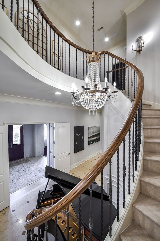 staircase with visible vents, recessed lighting, crown molding, and a high ceiling