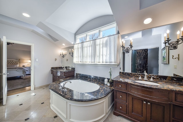 ensuite bathroom featuring vaulted ceiling, two vanities, a bath, ensuite bath, and a sink