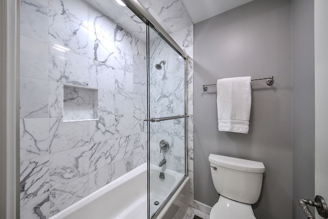 bathroom featuring shower / bath combination with glass door and toilet