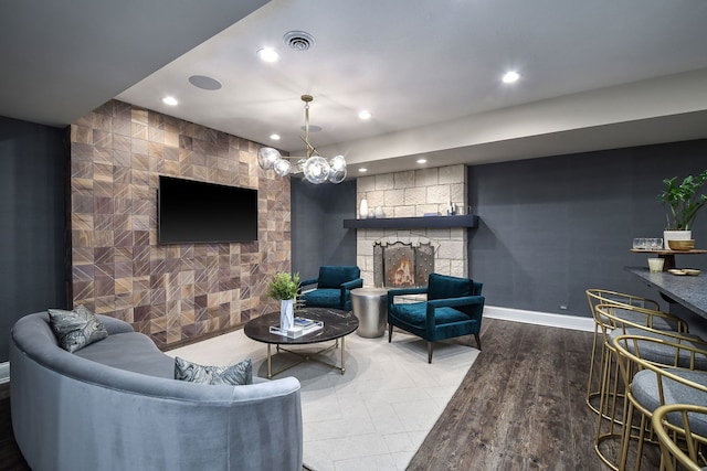 living room with visible vents, baseboards, recessed lighting, a fireplace, and an accent wall