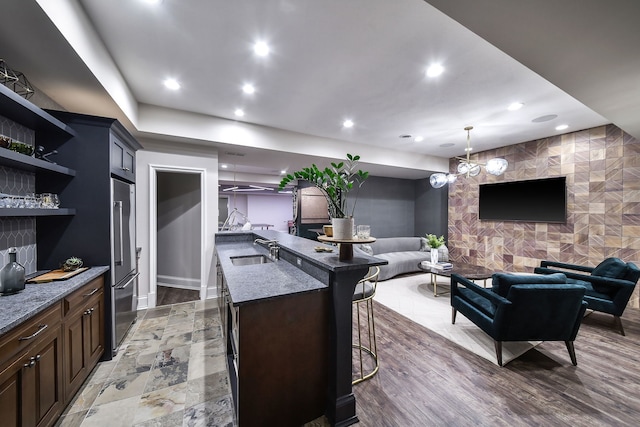 kitchen featuring recessed lighting, open floor plan, high end fridge, and a sink