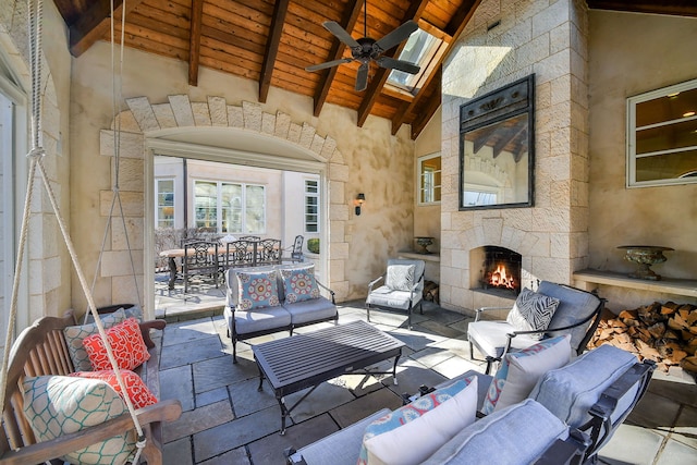 living room with wood ceiling, beam ceiling, an outdoor stone fireplace, high vaulted ceiling, and a ceiling fan