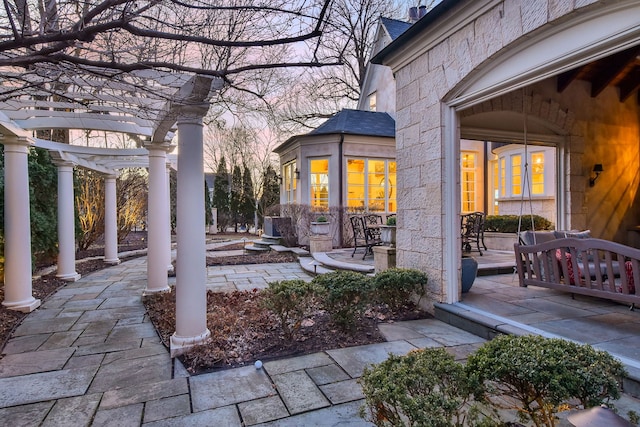 patio terrace at dusk with a porch and a pergola