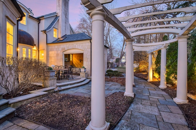 patio terrace at dusk featuring a pergola