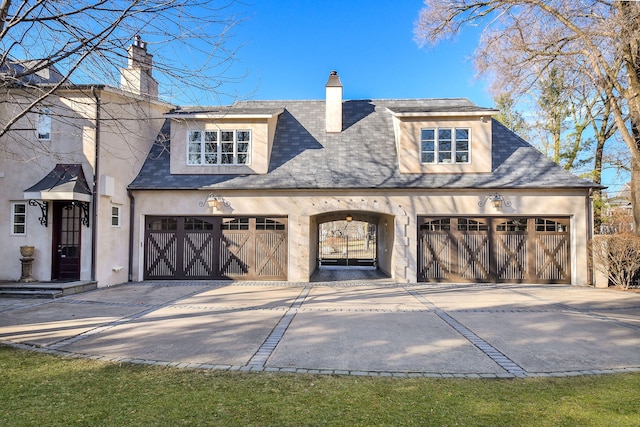 view of front of property featuring stucco siding, driveway, and a chimney