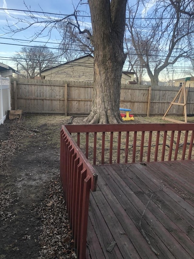 wooden deck with a fenced backyard