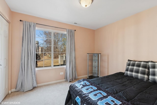 carpeted bedroom with visible vents, multiple windows, and baseboards