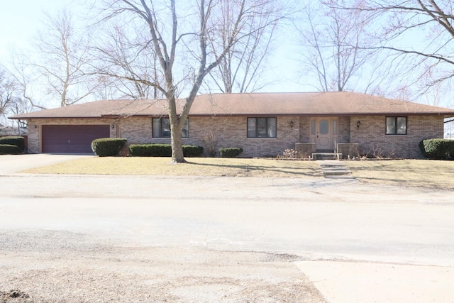 ranch-style home with brick siding, an attached garage, and concrete driveway