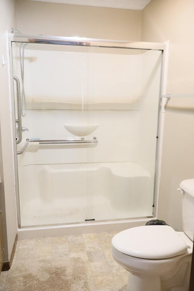 full bath with toilet and a shower stall