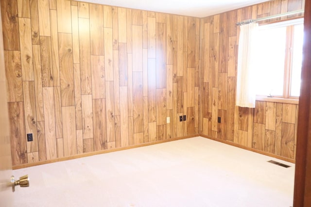 spare room with wooden walls and visible vents