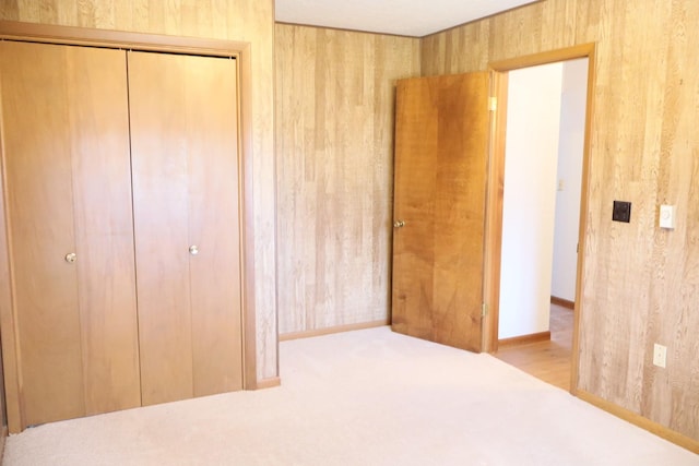 unfurnished bedroom featuring a closet and wood walls