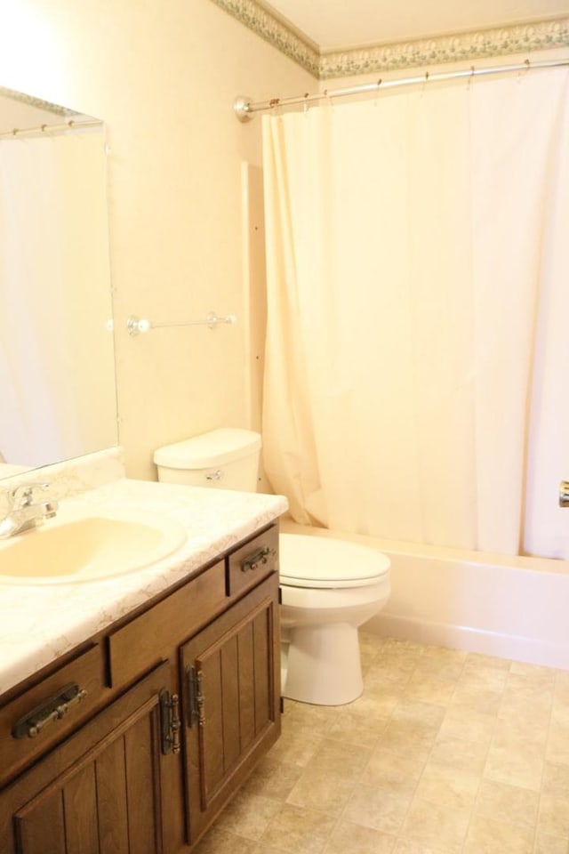 bathroom featuring vanity, shower / tub combo, and toilet