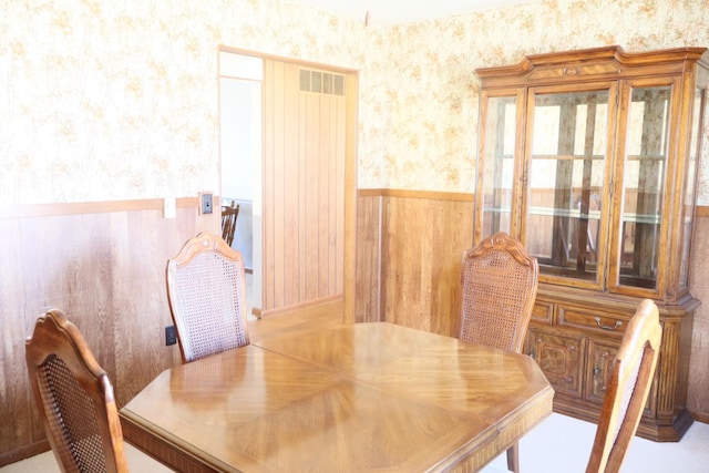 dining room with wainscoting and wallpapered walls