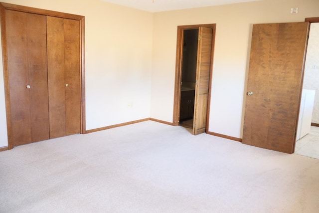 unfurnished bedroom with light colored carpet and baseboards