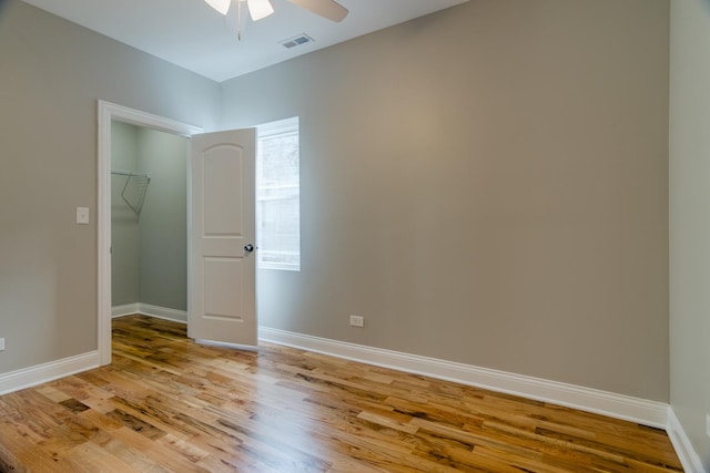 empty room featuring visible vents, baseboards, light wood-type flooring, and a ceiling fan