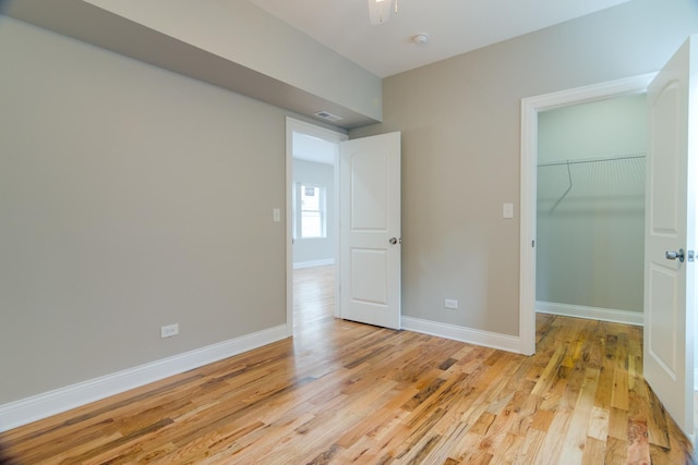 empty room featuring visible vents, baseboards, and light wood-type flooring