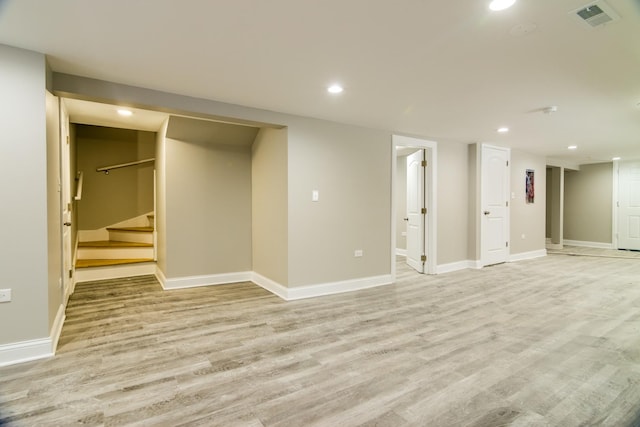 finished basement featuring stairway, visible vents, baseboards, recessed lighting, and light wood-style floors