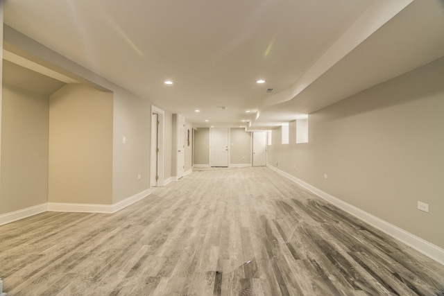 finished below grade area featuring recessed lighting, baseboards, and light wood finished floors