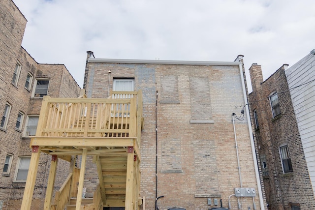 back of house with stairs and brick siding