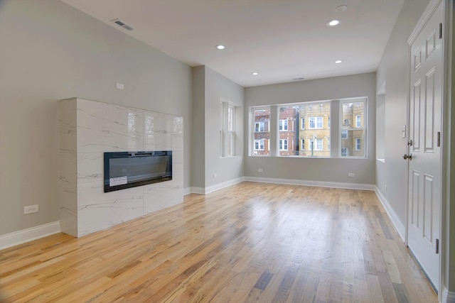 unfurnished living room with recessed lighting, visible vents, light wood-style flooring, and a fireplace