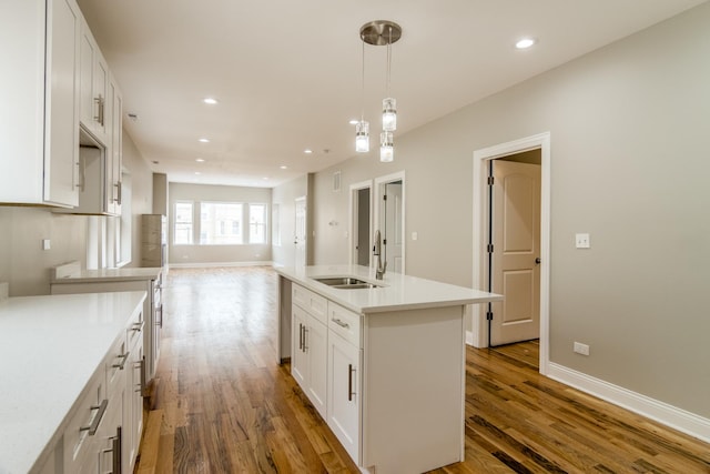 kitchen featuring a sink, wood finished floors, recessed lighting, white cabinets, and light countertops