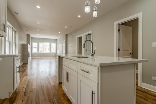 kitchen featuring recessed lighting, white cabinets, wood finished floors, and a sink