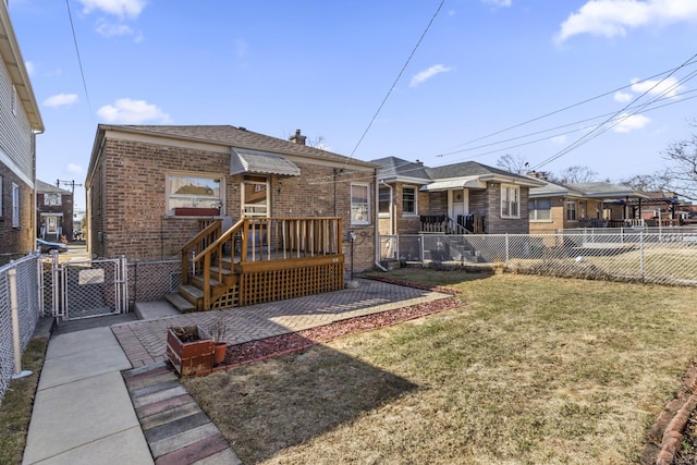 back of house featuring a gate, fence private yard, brick siding, and a lawn