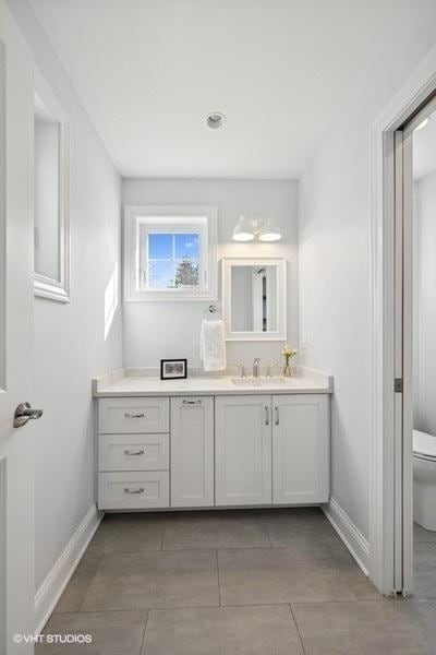 bathroom featuring vanity, toilet, and baseboards