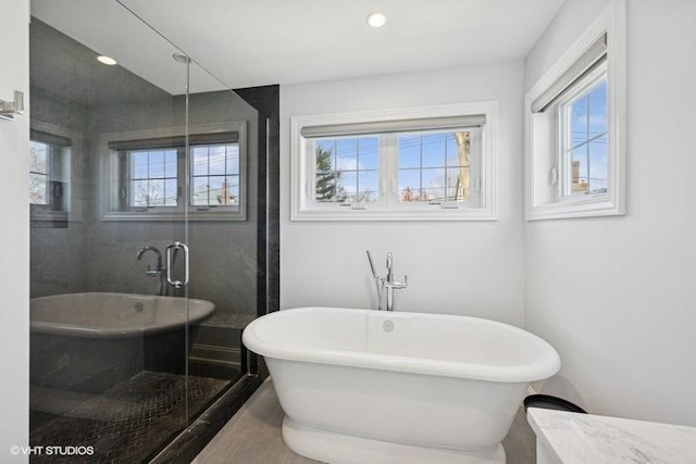 full bath featuring recessed lighting, a shower stall, and a freestanding bath