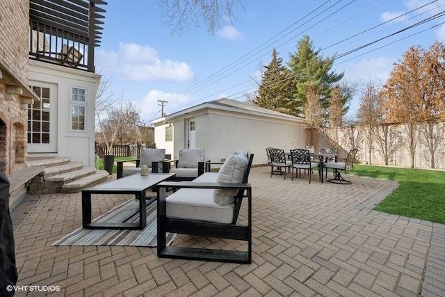 view of patio / terrace with fence, entry steps, an outdoor hangout area, a balcony, and outdoor dining space