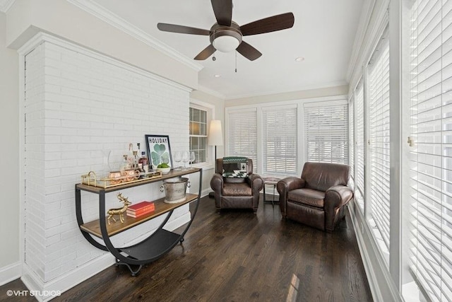 sitting room with ceiling fan, baseboards, wood finished floors, and ornamental molding