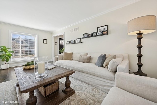 living area with crown molding, wood finished floors, and visible vents