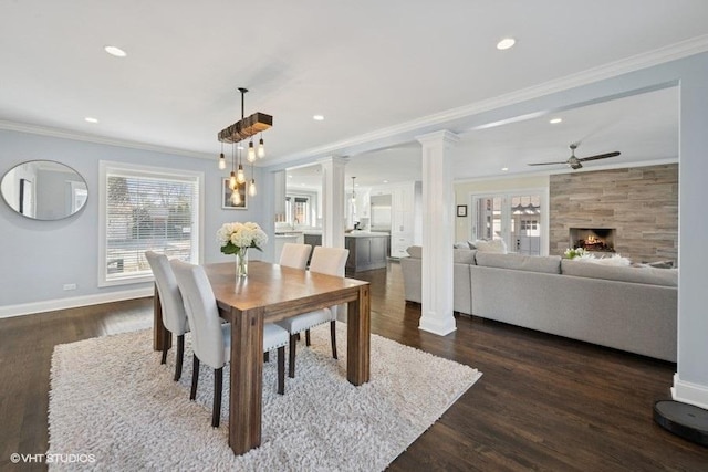 dining space featuring crown molding, dark wood-style flooring, and ornate columns