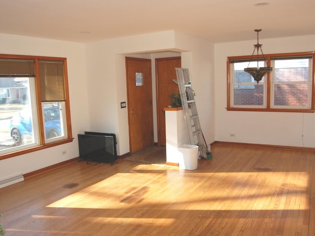 spare room with baseboards and wood finished floors