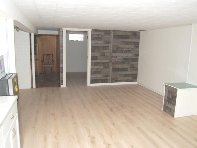 unfurnished living room featuring light wood-style floors and baseboards