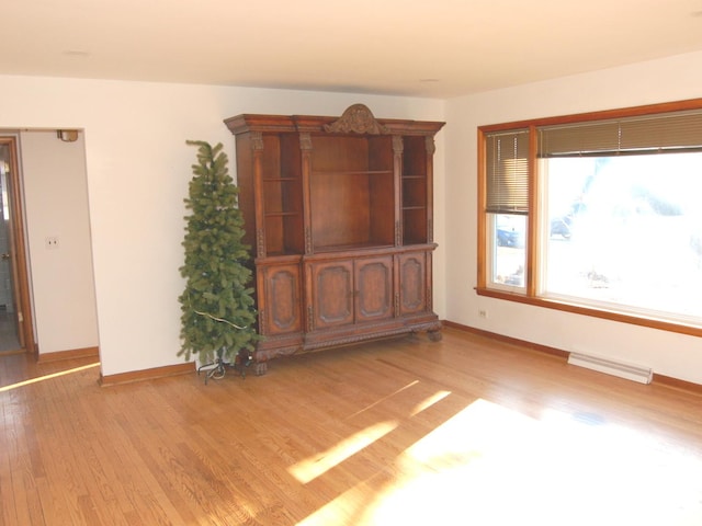 spare room with baseboards, visible vents, and light wood finished floors