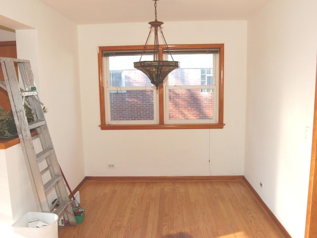 unfurnished dining area featuring plenty of natural light, light wood-style flooring, and baseboards