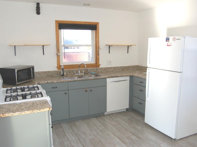 kitchen with white appliances, a sink, light wood-style flooring, and open shelves