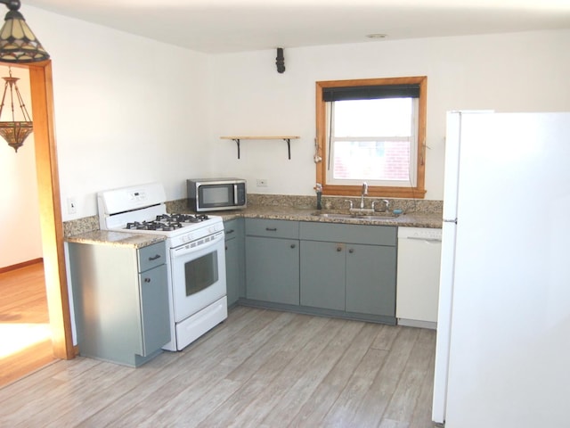 kitchen featuring white appliances, gray cabinetry, light wood-style floors, open shelves, and a sink